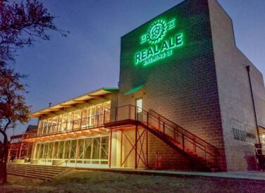 Real Ale Brewing Company at night with sign and lights